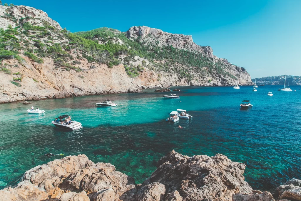 Mallorca travel guide:  beautiful clear blue sea with mountains in the background. 