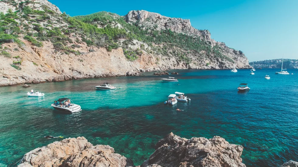 Mallorca travel guide: beautiful clear blue sea with mountains in the background.