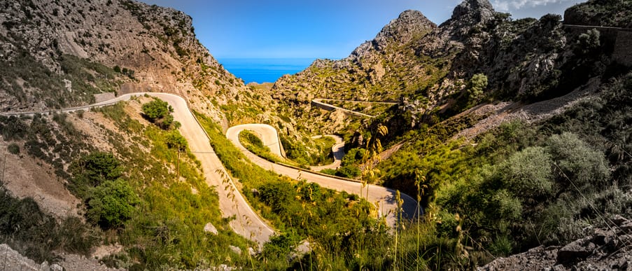 Places to visit in Mallorca: the serpentine route MA-2141 winding down to sa calobra through a valley in the area of coll dels reis in the famous sierra de tramuntana mountain range, mallorca, spain
