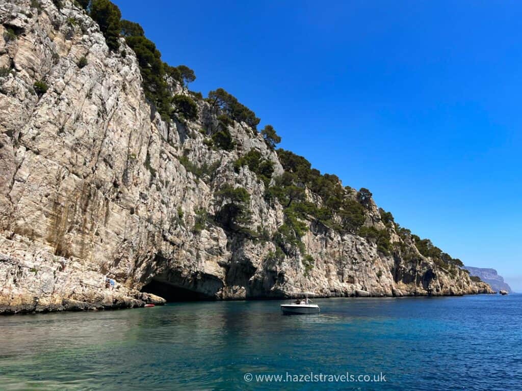 Descending cliff with trees and vegetation, as seen from the water at Cassis Calanques.