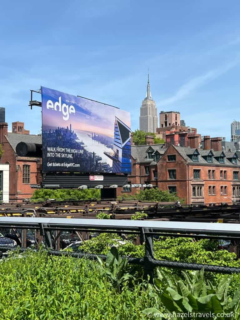 Railway tracks on the High Line NYC with a billboard advertising Edge and the Empire State building in the background