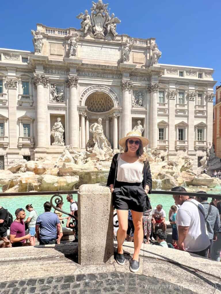 Woman poses outside the Trevi fountain in Rome, Italy.