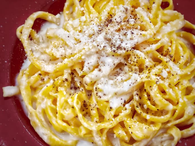 Roman pasta cacio e pepe - cheese and pepper- served with grated Parmesan on top.