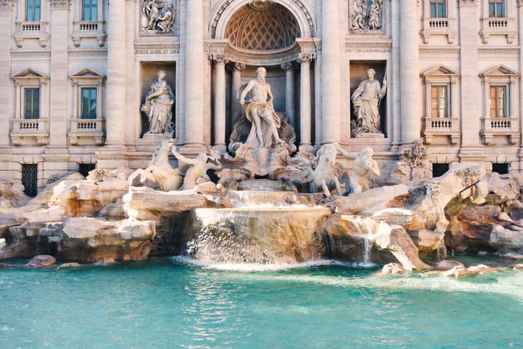 Visiting Rome is not complete without experiencing the Trevi Fountain, where intricate sculptures and flowing water create a captivating scene against a historic building facade.