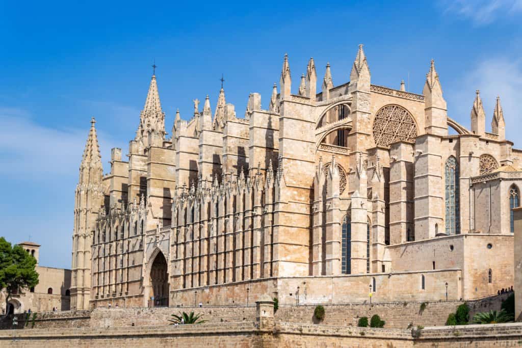 Large sandstone gothic cathedral in Palma De Mallorca, blue sky.