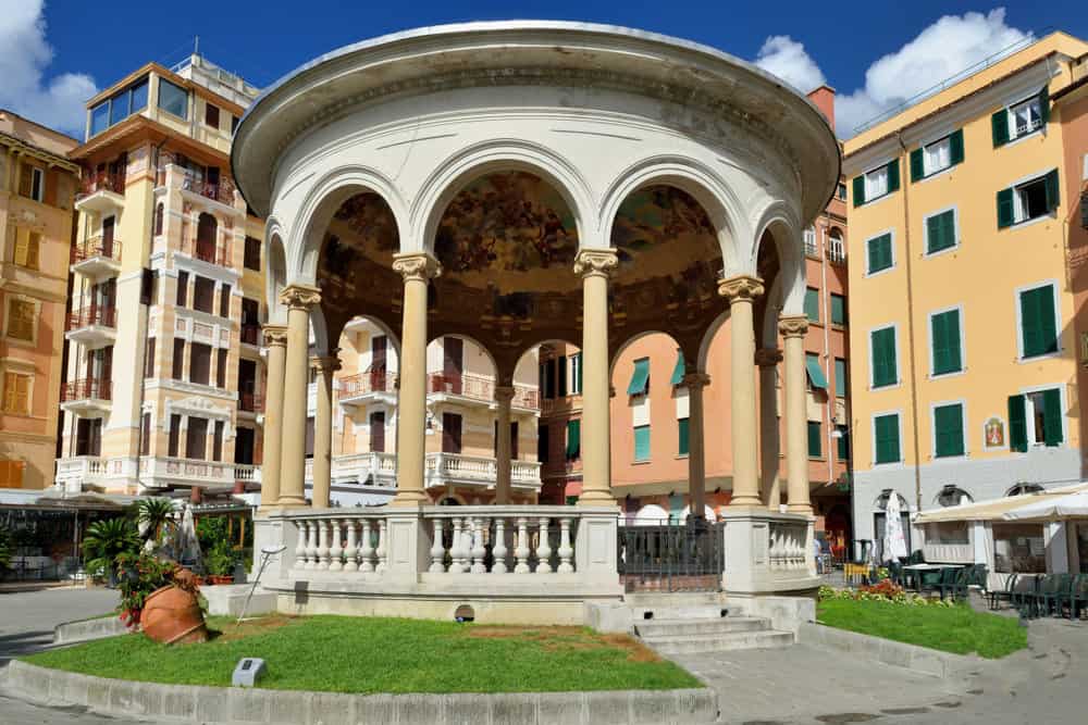 Chiosco della Musica in Rapallo, Italy — an elegant circular bandstand with arched columns and a domed ceiling adorned with vibrant frescoes, located near the seafront and surrounded by palm trees and historic buildings.