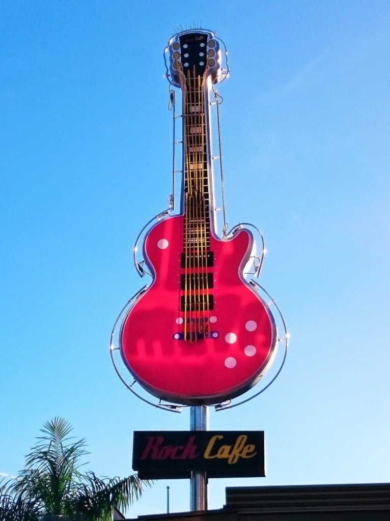 Huge red guitar sculpture sits on top of the Rock Cafe with a blue sky background.