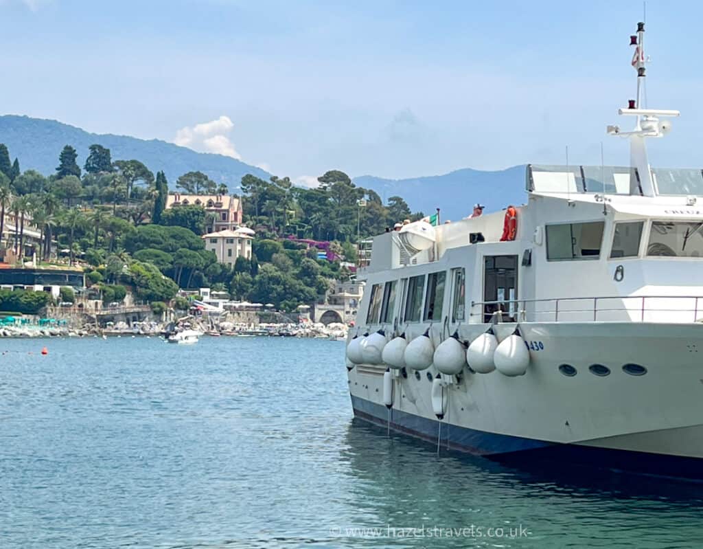 ChatGPT said:Ferry boat docked near the coastline of the Italian Riviera, with elegant villas, lush greenery, and distant hills visible across the calm blue water.