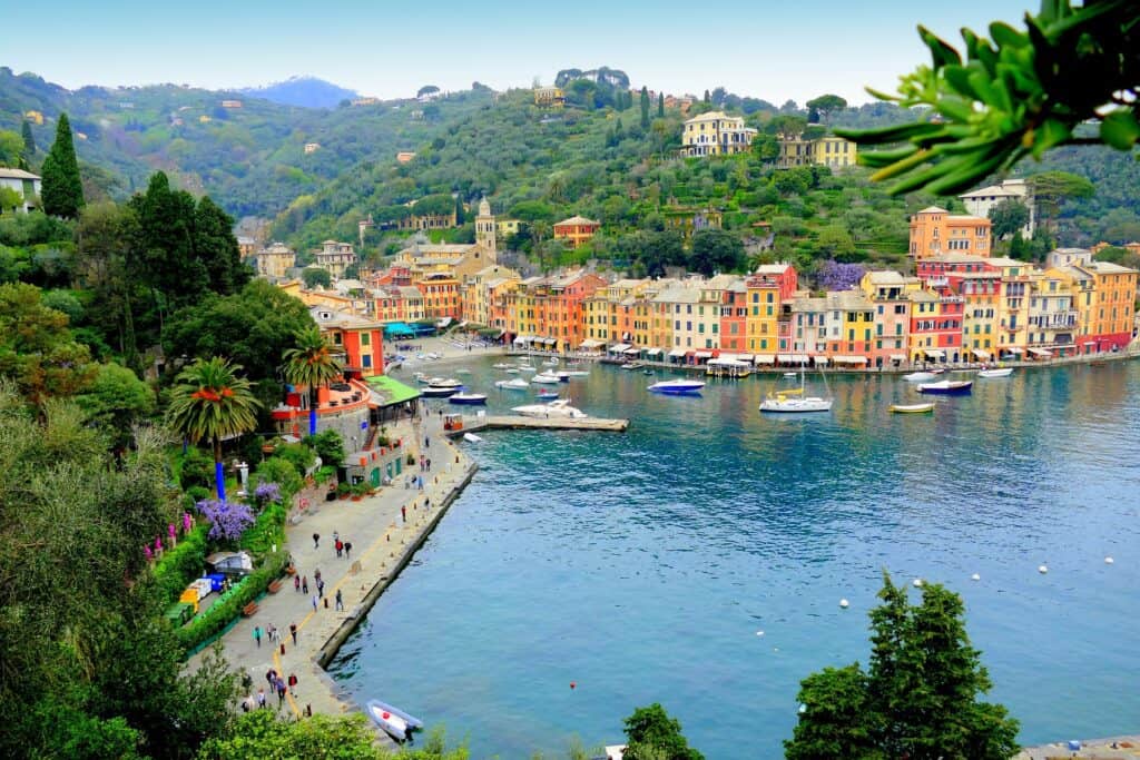 ChatGPT said:Panoramic view of Portofino, Italy, showing its colourful harbourside buildings, boats moored in the turquoise bay, and lush green hills rising in the background.