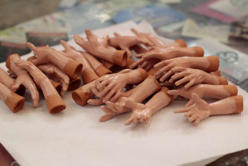A pile of plastic toy hands on a white surface.