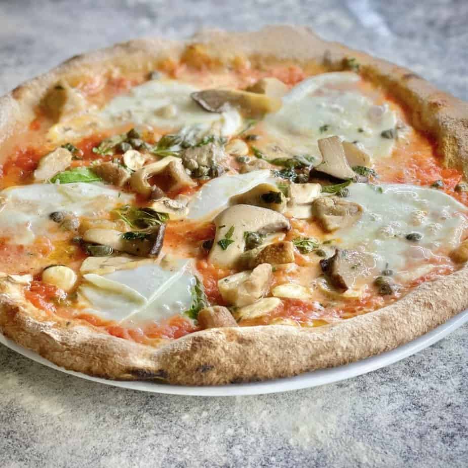 a pizza sitting on top of a white plate.