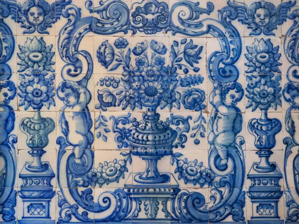 Blue and white ornamental tiles featuring cherubs, floral motifs, and intricate patterns.