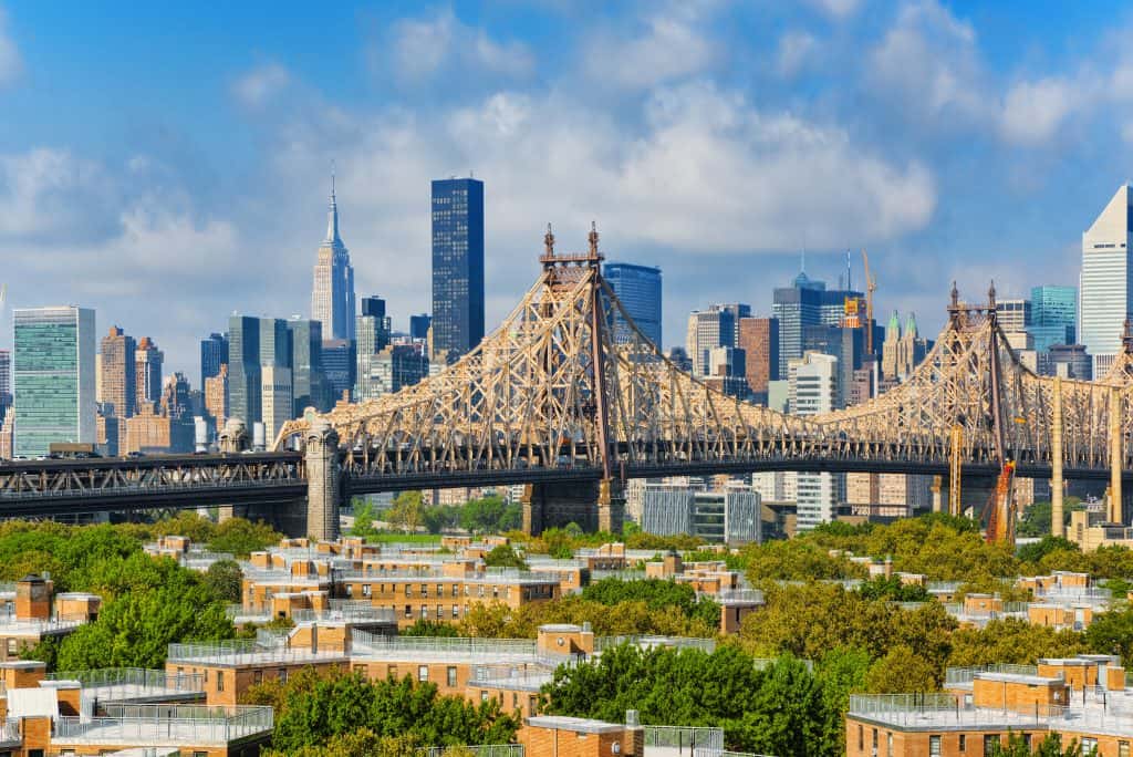 Famous bridges in New York. A panoramic view of a steel suspension bridge with the new york city skyline in the background.