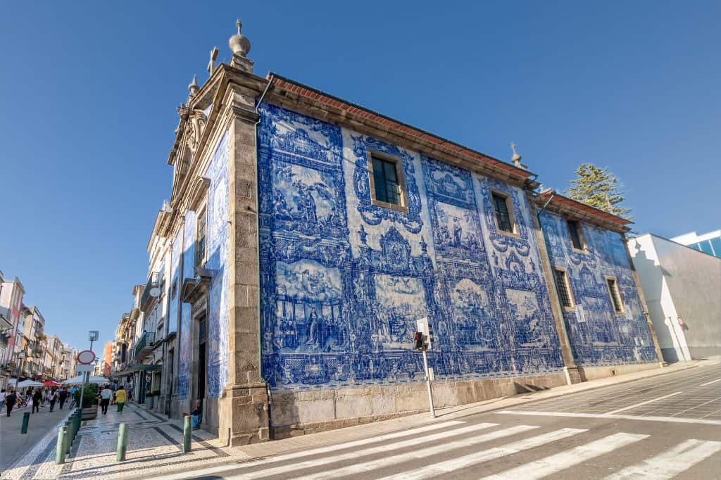 Historic building adorned with traditional blue and white azulejo tiles in portugal, under a clear blue sky.