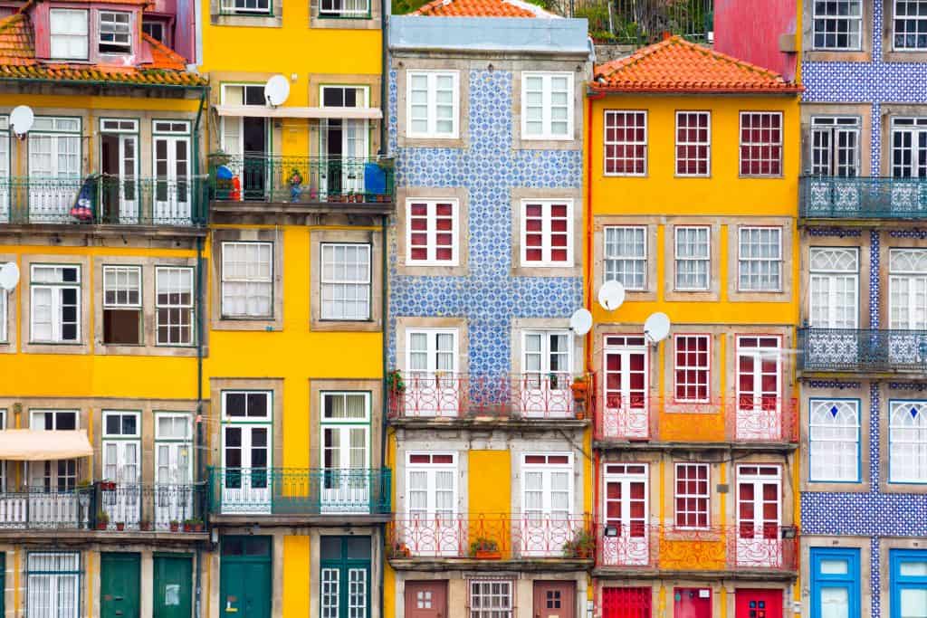 Colorful facades of traditional houses in porto, portugal, with balconies and patterned tiles.