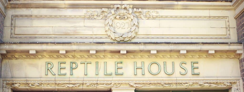 The stone building entrance labeled "Reptile House" features intricate carvings and the year "1927" inscribed above. Fans looking for Harry Potter things to do in London might find this spot intriguingly reminiscent of scenes set in iconic magical locations.