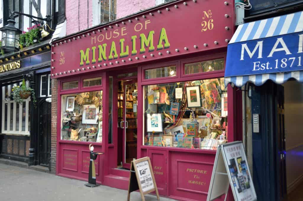 Discover the House of MinaLima, a must-see for Harry Potter enthusiasts in London. Its red facade and vibrant displays of books and prints beckon you with signs that say "Picture the Magic!" and "No 26."