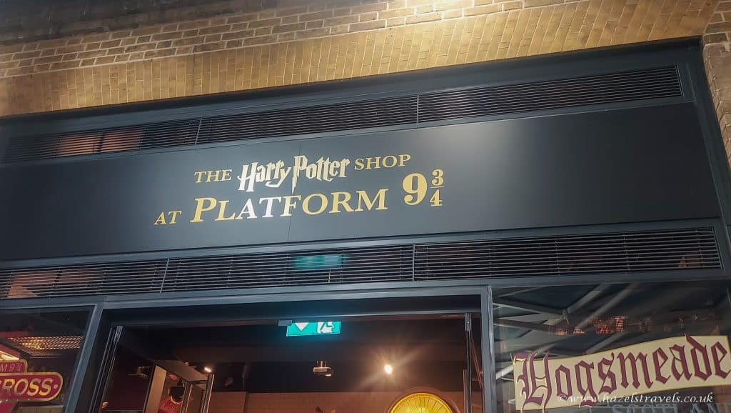 Sign for the Harry Potter Shop at Platform 9¾, with parts of Hogmeade decor visible below.