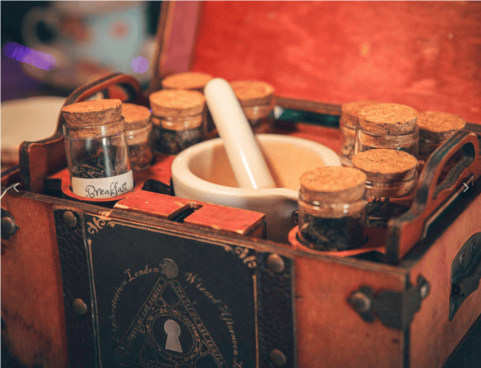 Wooden box with small cork-lidded jars and a mortar and pestle inside. The jars contain various herbs or spices. The box has decorative designs and a label reading "Breakfast.