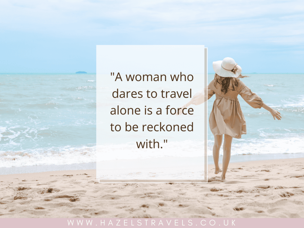Woman in a dress and hat walks toward the ocean on a sandy beach. Text beside her reads, "A woman who dares to travel alone is a force to be reckoned with.