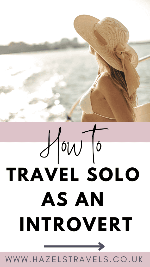 A woman in a sun hat and swimwear looks over the water from a boat, with text reading, "How to Travel Solo as an Introvert." Website URL at the bottom.