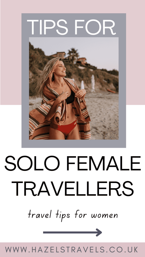 Woman at the beach wrapped in a blanket. Text overlay: "Tips for Solo Female Travellers, travel tips for women, hazelstravels.co.uk.