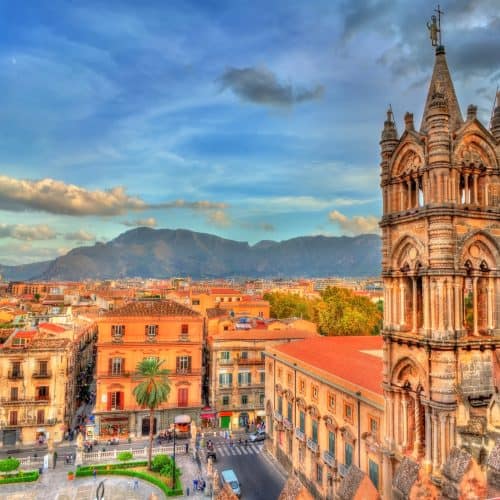 Vibrant cityscape of a historic Mexican town featuring colonial architecture, colourful buildings, and a scenic mountain backdrop at sunset, perfect for travel enthusiasts.