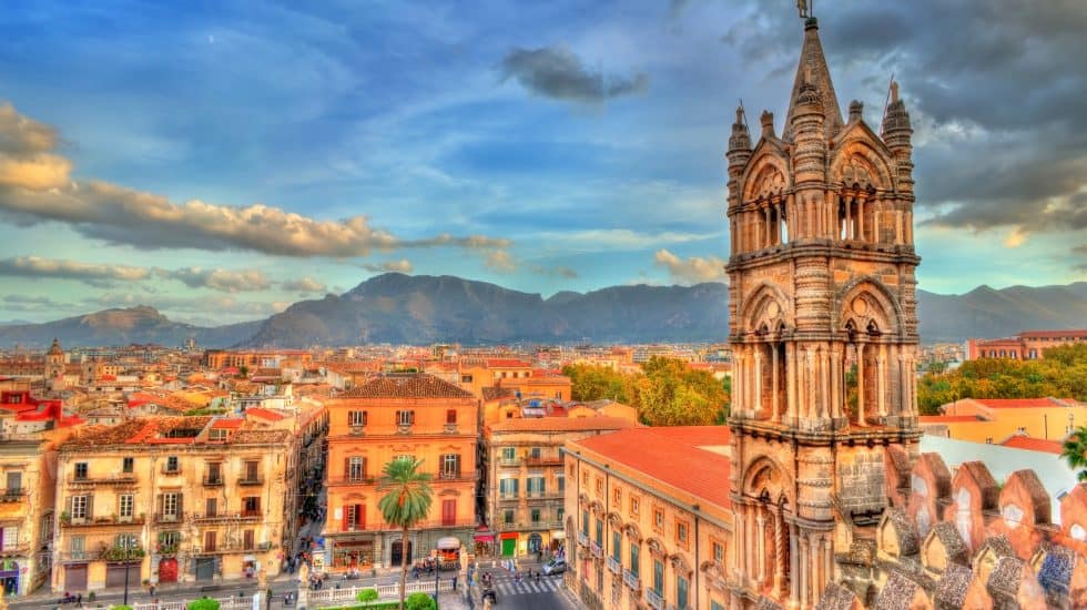 Vibrant cityscape of a historic Mexican town featuring colonial architecture, colourful buildings, and a scenic mountain backdrop at sunset, perfect for travel enthusiasts.