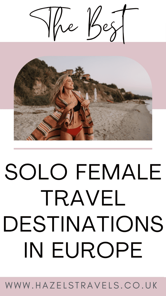 A woman enjoying solo female travel on a beach in Europe, dressed in swimwear and a cover-up, with scenic cliffs and beach umbrellas in the background.