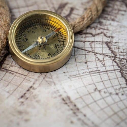 Vintage brass compass on old world map, symbolising travel and exploration for Hazel's Travels SEO content.