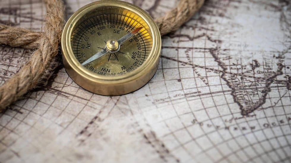 Vintage brass compass on old world map, symbolising travel and exploration for Hazel's Travels SEO content.