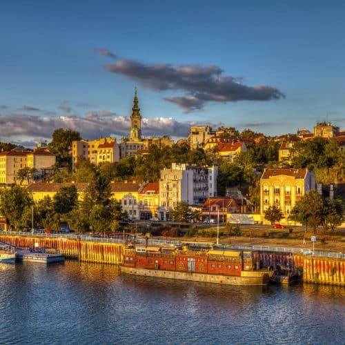 Vibrant cityscape of Bratislava at sunset showcasing historic buildings, riverfront, and Dóm svätého Martina, capturing the charm of Slovakia's capital.