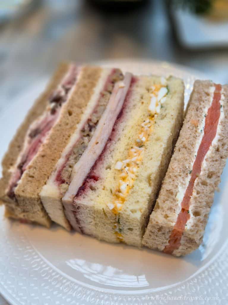 Delicious assorted sandwiches with fresh bread, filling options including turkey, ham, and egg salad, perfect for travel snacks or picnics in the UK.