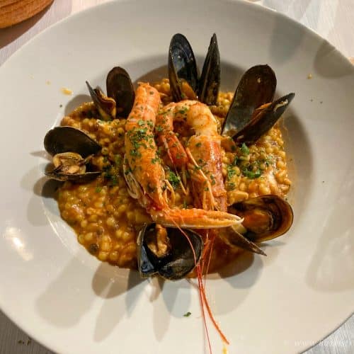 Delicious seafood paella with prawns and mussels served on a white plate, showcasing traditional Spanish cuisine at Hazel's Travels. Perfect for seafood lovers and travel enthusiasts.
