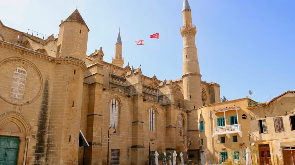 Stunning view of a historic Middle Eastern castle with tall minarets, beige stone walls, and blue sky, showcasing architecture and cultural landmarks.