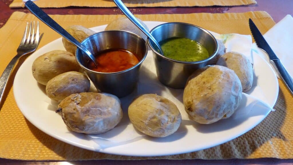 Fresh Canarian starters with potatoes served with mojo sauce, two pots one red one green.