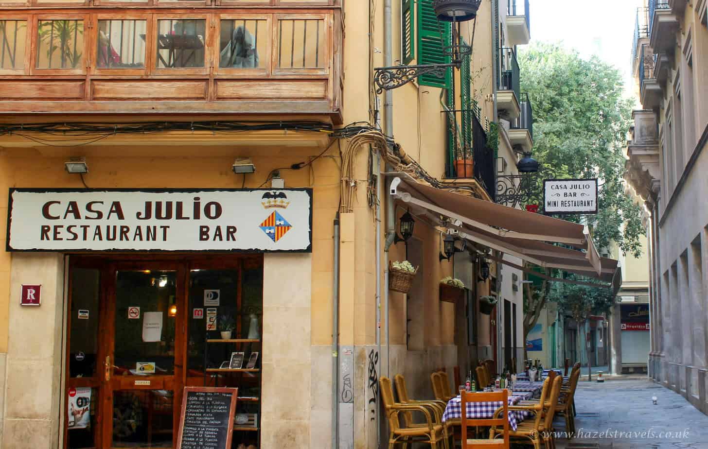 Casa julio restaurant bar exterior with outdoor seating in a narrow street in Barcelona, Spain.