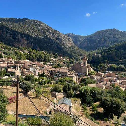 Picturesque mountain village in Provence, France, with historic buildings, lush greenery, and scenic hills under a bright blue sky, perfect for travel and exploration.