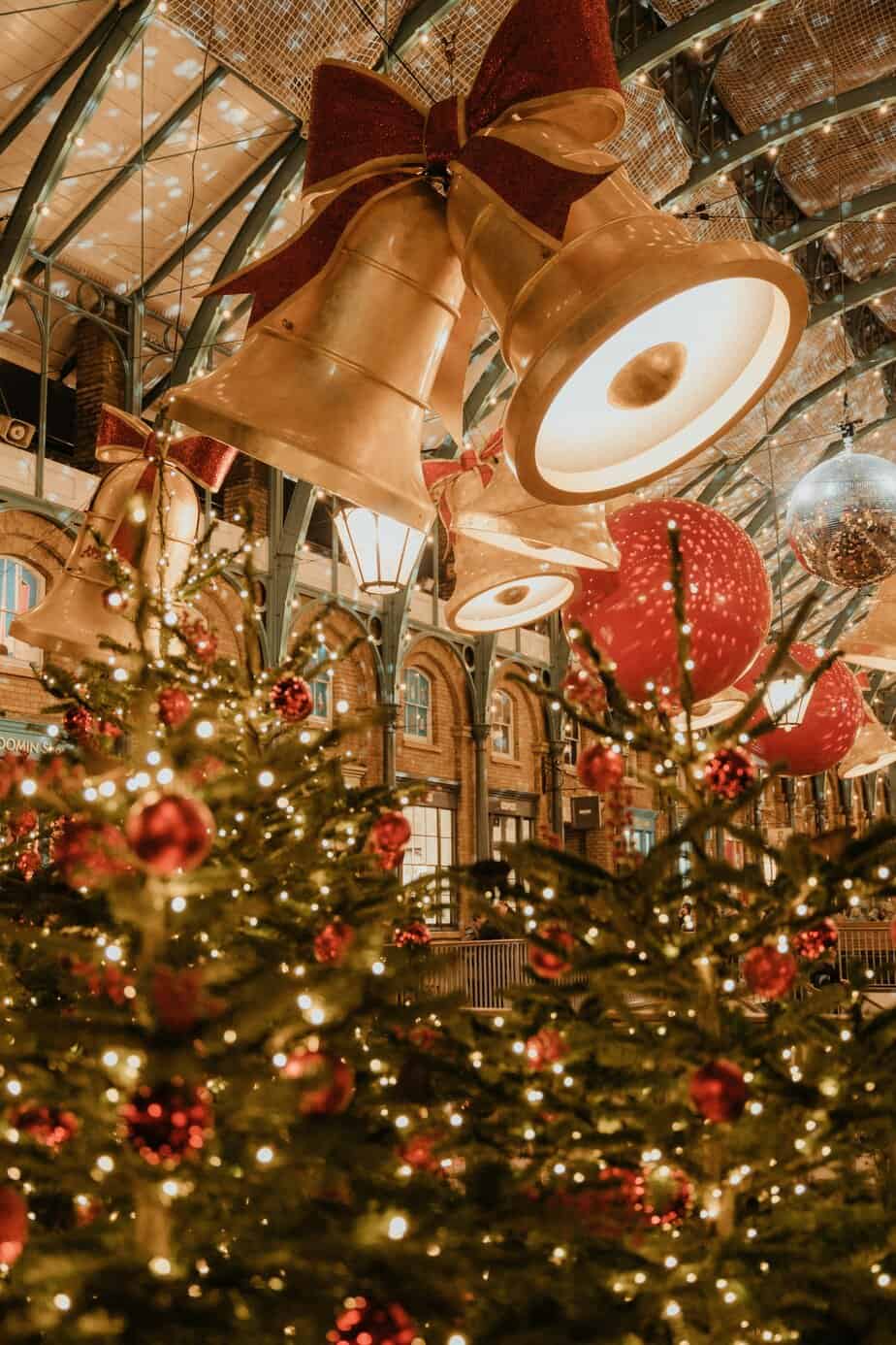 Sparkling tree and golden ornaments beneath warm lights at Covent Garden during the festive season.