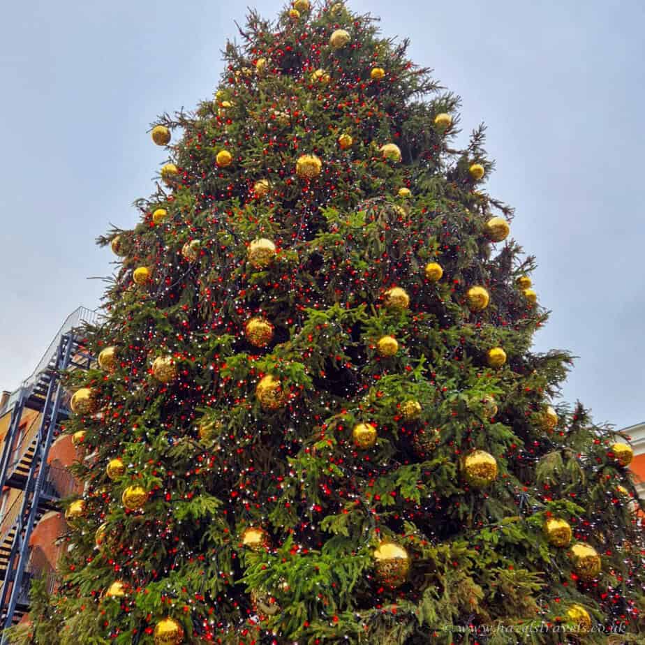 Large Christmas tree decorated with gold and red baubles in Covent garden in London