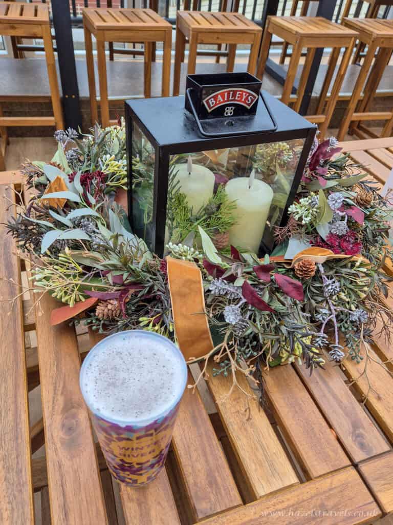 Christmas table decoration with wreath and candle on a table outside