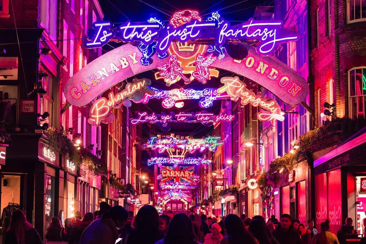 Carnaby Street Christmas lights with colourful arches and festive crowds in London’s West End