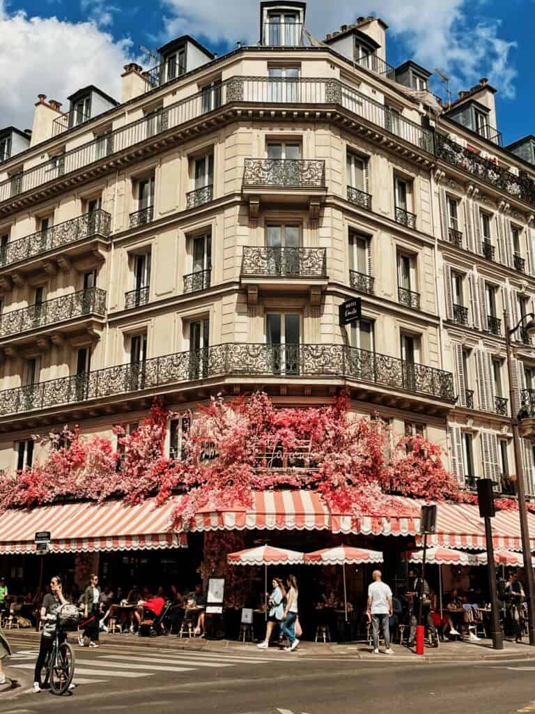 Café in Le Marais, Paris — Elegant corner café with a red floral façade and outdoor seating in the Le Marais district.