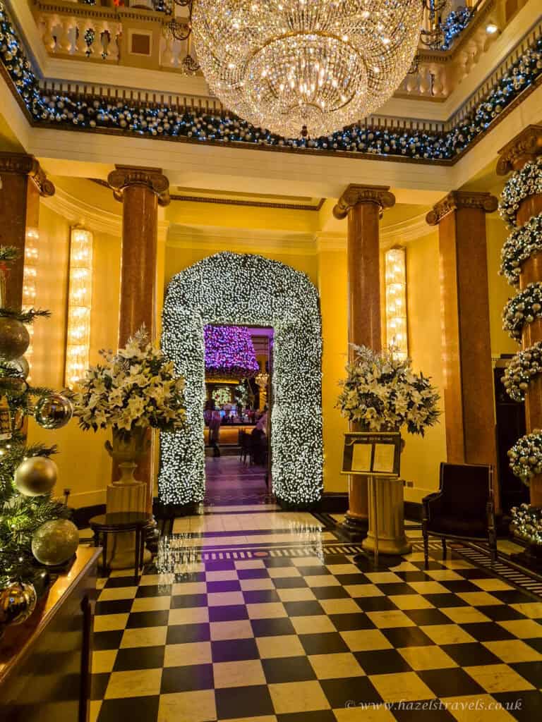 The Dome Edinburgh interior at Christmas, with grand columns and white floral garlands around the entrance hall.