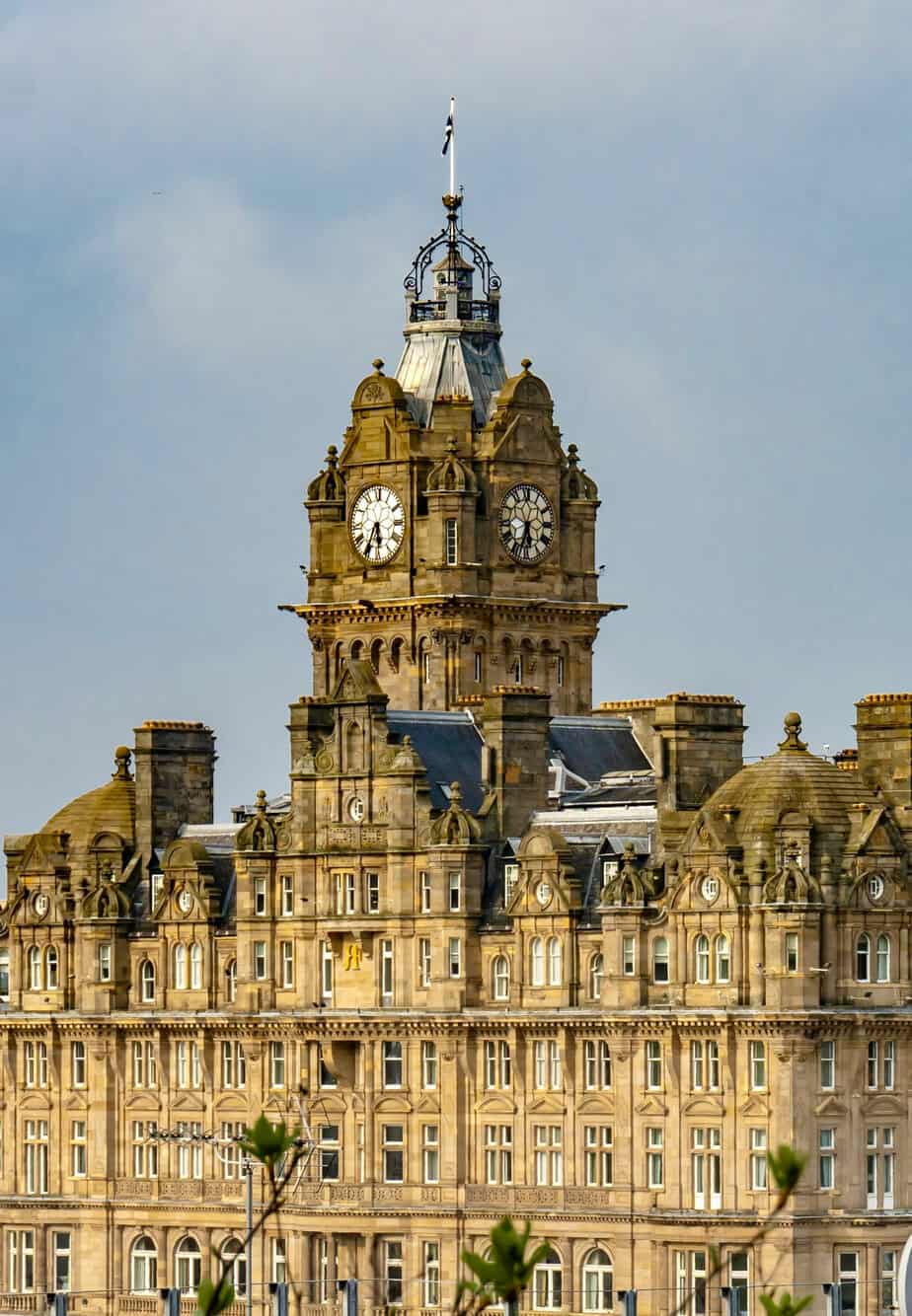 Close-up of the ornate façade of The Balmoral Hotel in Edinburgh lit by afternoon sun.