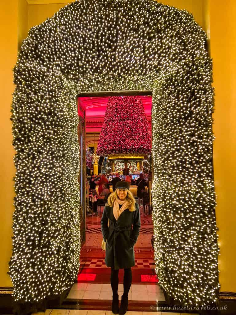 Light-covered archway glowing gold and pink at The Dome Edinburgh, with people posing for photos inside.