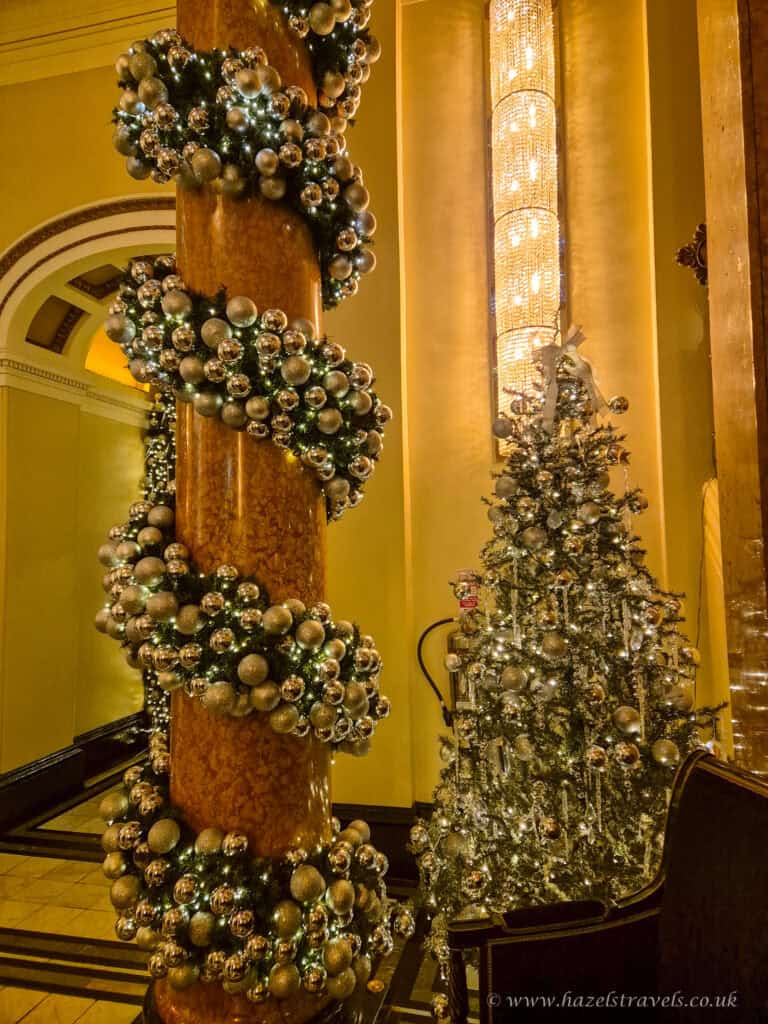 Golden spiral staircase decorated with twinkling fairy lights inside The Dome Edinburgh during the festive season.