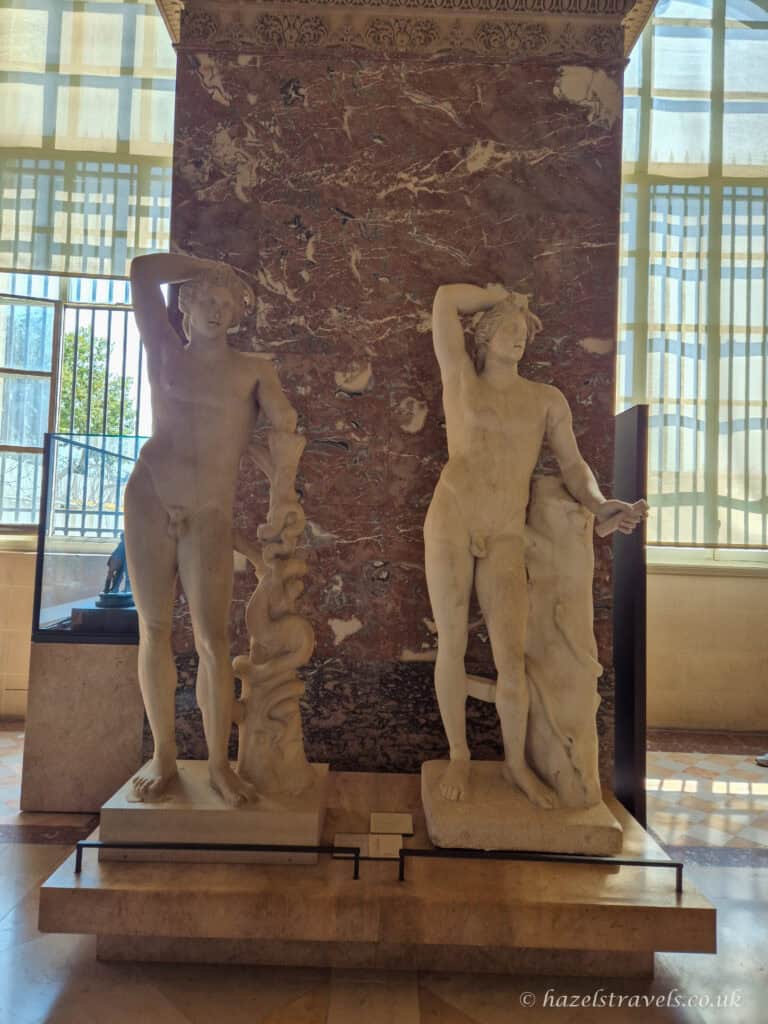 Classical sculptures, Louvre Museum — Marble statues illuminated by natural light in one of the sculpture galleries.