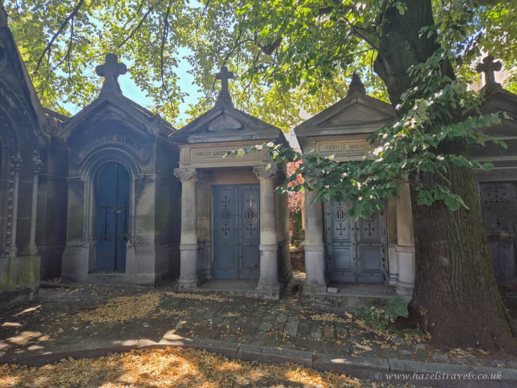 Père Lachaise Cemetery, Paris - Peaceful pathway lined with historic tombs and leafy trees.