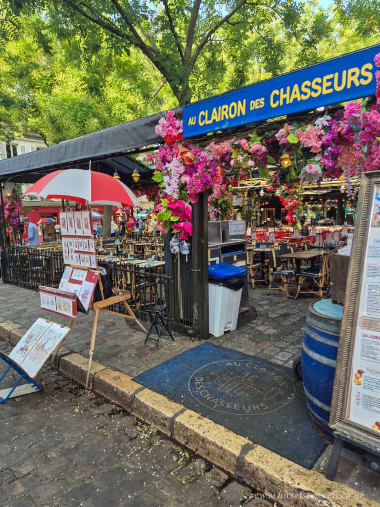 La Maison Rose, Montmartre — Pretty pink restaurant covered in ivy on a cobbled corner street in Paris.